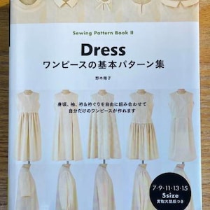 May include: A book titled "Dress: ワンピースの基本パターン集" by 野木陽子. The book features sewing patterns for five different dresses, with illustrations of each dress style. The book cover also includes the text "Sewing Pattern Book II" and "7-9-11-13-15 5size 実物大型紙つき".