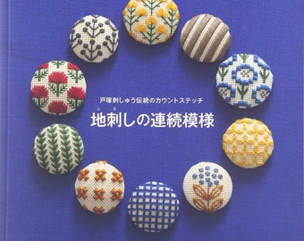 Puede incluir: Una portada de libro con el título "Jizashi no Renzo Kumigata" en japonés, que presenta un fondo azul con nueve círculos bordados en varios colores y patrones.