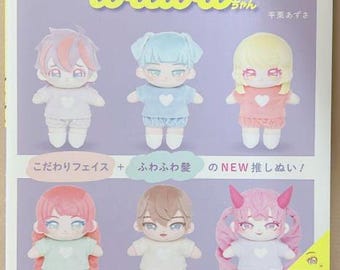 May include: A book cover featuring six plush toys with different colored hair and clothing. The book title is "wawawa-chan" and the text "te-zukuri susumu!!" is also visible. The book cover is pink and purple with a white background.