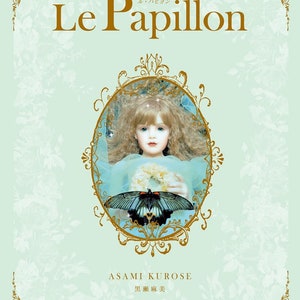 Może przedstawiać: Okładka książki z tytułem "Le Papillon" w złotych literach. Okładka przedstawia lalkę z blond włosami i motylem. Tło jest jasnozielone z kwiatowymi wzorami. Widnieje również nazwisko autora, Asami Kurose.