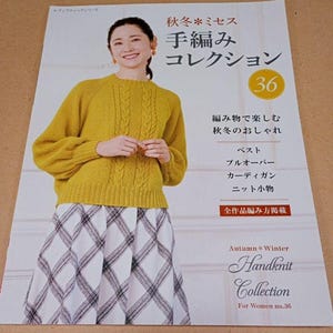 Pode incluir: Uma mulher com um suéter amarelo mostarda de malha de cabo e uma saia xadrez aparece na capa de um livro de padrões de tricô japonês. O livro é intitulado "Handknit Collection" e inclui texto japonês. O número 36 está em um círculo amarelo.
