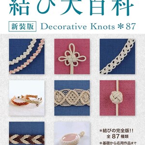Könnte beinhalten: Ein Buch mit dem Titel "結び大百科" (Knots Encyclopedia) mit dem Untertitel "Decorative Knots *87" in Japanisch und Englisch. Der Umschlag zeigt eine Vielzahl von Knoten in verschiedenen Farben und Stilen, darunter ein rosa-weißer Knoten, ein weißer Knoten, ein beiger Knoten, ein braun-weißer Knoten und ein rosa-weißer Knoten mit einem Anhänger.