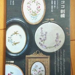 May include: A book cover featuring Rococo ribbon embroidery with classic and original designs. The cover displays various embroidered floral patterns in oval and circular frames. Text includes the title "Rococo Embroidery" and author's name.