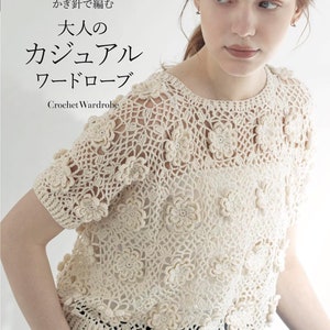 May include: A crochet book cover featuring a woman wearing a white crochet top with a floral design. The book title is "大人の カジュアル  ワードローブ Crochet Wardrobe" in Japanese.