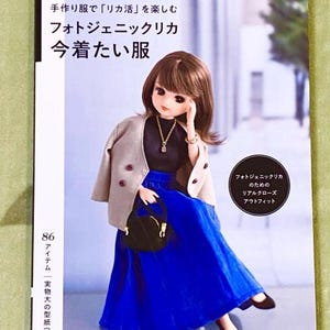 May include: A book titled "Photogenic LiccA" with a doll wearing a blue skirt, a beige jacket, and black shoes. The book cover features the text "Photogenic LiccA" and "Handmade clothes for LiccA dolls".