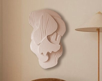 May include: Two brown, plush, oversized armchairs with rounded backs and seats, facing each other in a living room setting. A white, cone-shaped lamp with a gold base stands between the chairs. A large, abstract, white wall sculpture hangs on the wall behind the chairs.