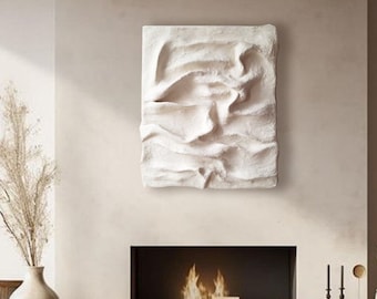 Peut inclure: Une sculpture murale texturée blanche est suspendue au-dessus d'une cheminée dans un salon minimaliste. La sculpture a un effet 3D et semble être faite de plâtre ou d'argile. La cheminée est entourée d'un manteau en bois et a un feu qui brûle à l'intérieur. La pièce est décorée d'un vase de fleurs séchées et d'une sculpture en bois.