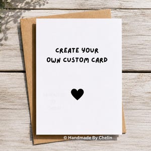 May include: A white greeting card with the black text CREATE YOUR OWN CUSTOM CARD and a small black heart icon centered below. The card is placed on top of a brown kraft paper envelope. The text Handmade By Chelin appears at the bottom.