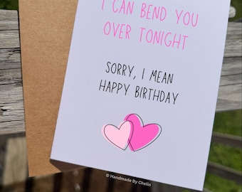 May include: A white greeting card with a brown envelope featuring the pink text I CAN BEND YOU OVER TONIGHT and black text SORRY, I MEAN HAPPY BIRTHDAY, with two overlapping pink hearts at the bottom and the text HANDMADE BY CHELIN.