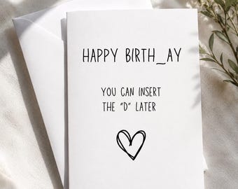 May include: A white greeting card with the text "HAPPY BIRTH_AY, YOU CAN INSERT THE 'D' LATER" and a hand-drawn heart. The card is inside a white envelope, with greenery in the background.