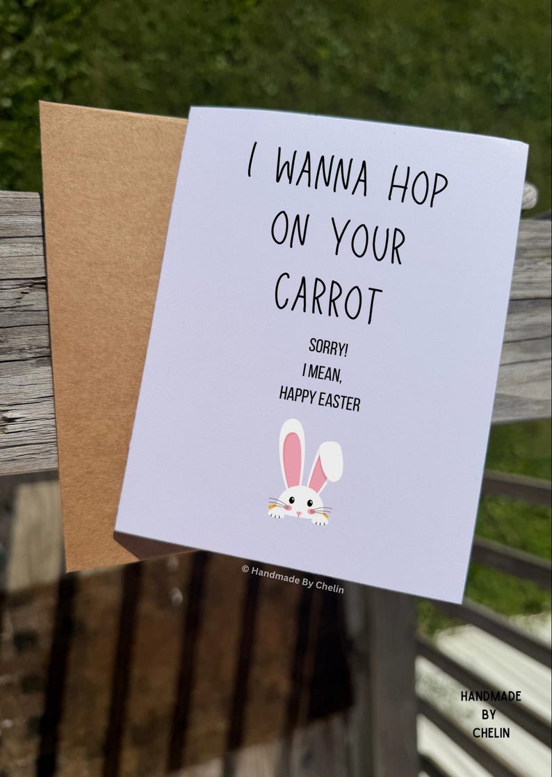 May include: A white greeting card with a brown envelope featuring the black text I WANNA HOP ON YOUR CARROT SORRY! I MEAN, HAPPY EASTER and a small illustration of a white rabbit with pink ears holding a carrot. The text Handmade By Chelin is visible.