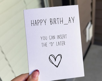 May include: A white rectangular greeting card with black text that reads HAPPY BIRTH_AY, followed by the text YOU CAN INSERT THE D LATER, and a hand-drawn black heart symbol centered at the bottom of the card.