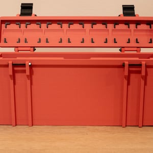 May include: A red plastic storage box with a hinged lid and multiple compartments. The lid is open and the box is empty.