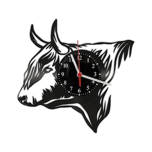 Könnte beinhalten: Schwarz-weiße Schallplattenuhr in Form eines Highland-Kuhkopfes. Das Zifferblatt der Uhr ist schwarz mit weißen Zahlen und Zeigern.