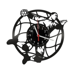 Könnte beinhalten: Schwarze Schallplattenuhr mit der Silhouette eines Handballspielers, der sich nach einem Ball stürzt. Das Zifferblatt der Uhr ist schwarz mit weißen Zahlen und Zeigern.