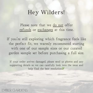 Peut inclure: Texte sur fond flou : &laquo; Hey Wilders! &raquo; et informations sur les remboursements, les &eacute;changes et les &eacute;chantillons de parfum. Le texte mentionne &eacute;galement la marche &agrave; suivre en cas de dommage. La marque &laquo; EMBER GARDENS &raquo; est en bas.