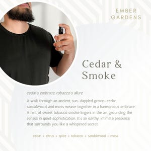 Peut inclure: Un flacon de parfum en verre transparent avec un vaporisateur noir est tenu par une personne. Le flacon est &eacute;tiquet&eacute; "Cedar & Smoke" avec la marque "Ember Gardens". La description mentionne le c&egrave;dre, le tabac, le bois de santal et la mousse.