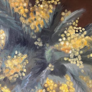 May include: A close-up of a painting of a bouquet of yellow mimosa flowers with dark green leaves against a dark brown background.
