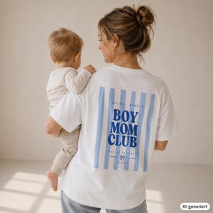 Könnte beinhalten: Ein weißes kurzärmeliges T-Shirt mit einem Rückendruck aus hellblauen vertikalen Streifen und dem dunkelblauen Text "OFFICIAL MEMBER BOY MOM CLUB RAISING COOL BOYS EST 2024" sowie einem kleinen Schleifensymbol unter dem Text.