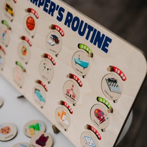 May include: A wooden board with a child's daily routine printed on it. The board has a series of circular slots with images and text, such as "Take bath", "Chess club", and "Painting". Each slot has a red "To Do" and green "Done" slider.