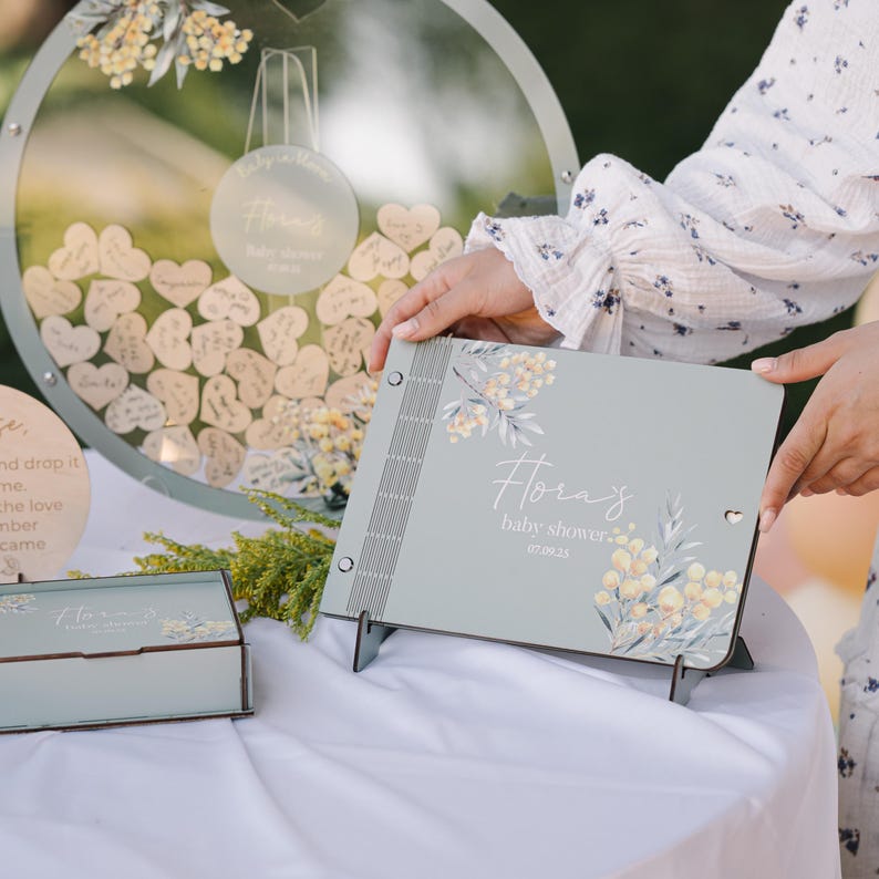May include: A light blue baby shower guest book with a floral design and the text "Hora's baby shower. 07.09.23".