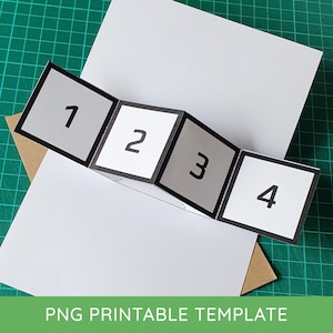 May include: A white and gray printable template with the numbers 1, 2, 3, and 4 displayed on a folding card. The card is on a green cutting mat. The text "PNG PRINTABLE TEMPLATE" is at the bottom.