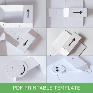 Peut inclure: Un modèle imprimable PDF avec plusieurs découpes de papier blanc, chacune avec des flèches noires indiquant les directions de pliage. L'image montre diverses étapes d'assemblage, avec des lignes pointillées et des lettres. Le texte "PDF PRINTABLE TEMPLATE" est en bas.