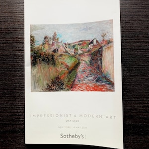 May include: A poster advertising an Impressionist & Modern Art Day Sale at Sotheby's in New York on 4 May 2011. The poster features a painting of a rural landscape with a winding path and houses.