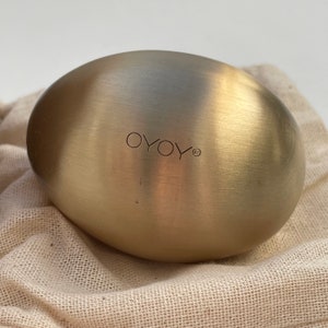 以下が含まれることがあります： 「OYOY」と刻まれた、金色の楕円形の金属製の物体です。