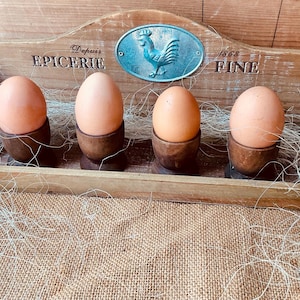 Een decoratief Franse kruidenierswinkelplank en vier eierdopjes