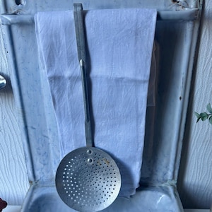 A vintage French enamel kitchen utensils drainer