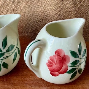 A matching set of three vintage pitchet rose jugs