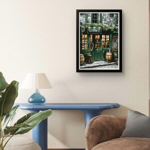 a cozy living room with a framed poster of a pub or bar, a blue table, and a brown sofa.