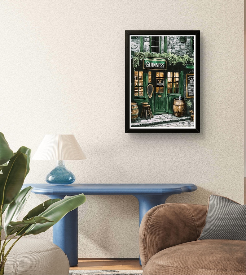 a cozy living room with a framed poster of a pub or bar, a blue table, and a brown sofa.