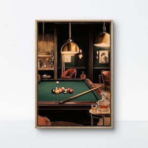May include: A framed print of a billiards room. The scene features a green felt pool table with billiard balls, a cue stick, and a decanter with two glasses. The room has dark green walls, gold pendant lights, and leather chairs.