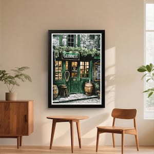 a framed painting of a pub with a green exterior and a sign that reads "GUINNESS". The painting is hanging on a wall, and there are two wooden chairs and a small table in front of it.