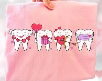 May include: Pink fabric with a graphic of four cartoon teeth. Each tooth has a different Valentine's Day theme: hearts, a gift, a heart with an arrow, and a mask. The teeth are smiling and surrounded by small hearts.