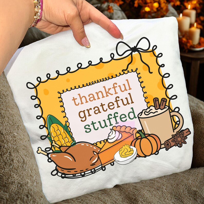 May include: White Thanksgiving-themed pillow with a decorative border and the words "thankful grateful stuffed." The design includes illustrations of a turkey, pumpkin pie, corn, pumpkin, and a mug of coffee.