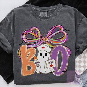 Pu&ograve; includere: Felpa grigio scuro con grafica "BOO" colorata. Il design presenta un fantasma con cappello da infermiera che tiene una siringa e una borsa medica, con un grande fiocco multicolore sopra. Piccoli pipistrelli sono sparsi.
