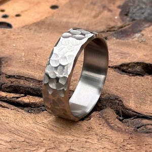May include: A silver hammered band ring with a smooth, polished interior.