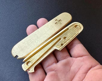 Brass scales for Victorinox 91mm Plus, featuring slots for a toothpick, tweezers, pen, and pushpins