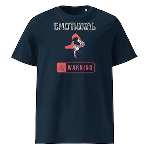 Può includere: T-shirt blu navy con la scritta "EMOTIONAL" sopra una grafica rossa e bianca di un grilletto e la scritta "WARNING" in un rettangolo rosso. La maglietta è a girocollo e maniche corte.