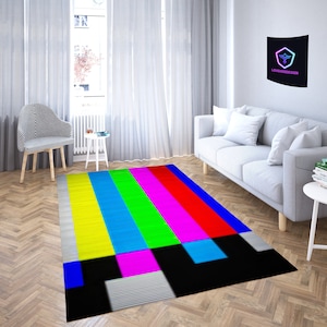 May include: A colorful rug with a television test pattern design. The rug has stripes of yellow, blue, green, pink, and red. The rug is on a wood floor.