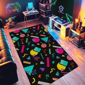 May include: A black and white geometric rug with colorful shapes and patterns. The rug features a variety of colors, including pink, blue, yellow, and green. The rug is perfect for adding a pop of color to any room.