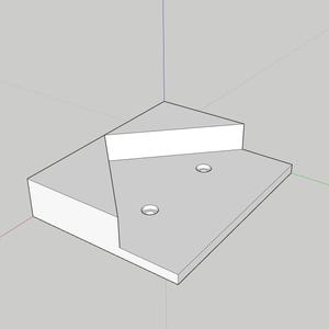 Op de afbeelding: Een 3D-gepresenteerd, geometrisch ontwerp van een hoekplank. De plank is voornamelijk grijs met witte accenten, met een trapsgewijs ontwerp en twee cirkelvormige gaten. De algehele vorm is driehoekig, geschikt voor hoekplaatsing.