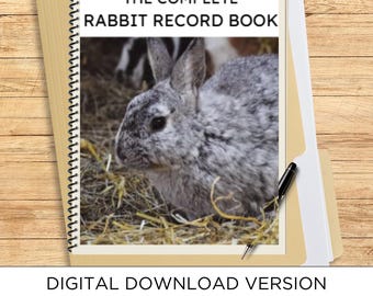 May include: A spiral-bound record book titled THE COMPLETE RABBIT RECORD BOOK featuring a photograph of a grey rabbit on the cover. The book includes 111 full pages and is a digital download version. A black pen rests on the side of the notebook.