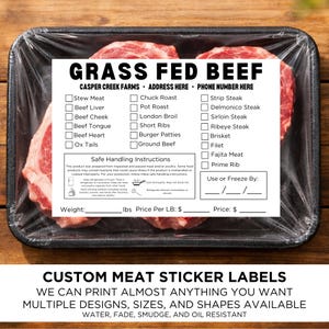 May include: A package of raw grass-fed beef steaks, wrapped in clear plastic, with a label listing various cuts of meat. The label includes safe handling instructions and space for weight and price. Text on the label reads "CUSTOM MEAT STICKER LABELS".