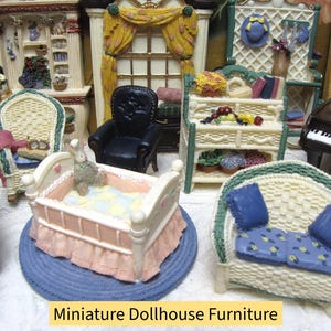 May include: A collection of miniature dollhouse furniture including a pink crib on a blue rug, a wicker-style sofa with blue cushions, a black armchair, a hutch with shelves, and a piano, all arranged together as a set of decorative items.