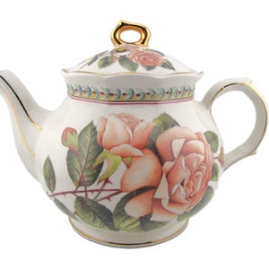 Peut inclure: Une théière en porcelaine blanche ornée d'un motif floral de roses couleur pêche et de feuilles vertes. La théière présente une anse, un bec verseur et un bouton de couvercle dorés, avec une bordure décorative de petites feuilles bleues et vertes.