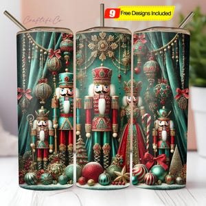 May include: A set of three stainless steel tumblers with a Christmas-themed design. Each tumbler features a different nutcracker soldier illustration in red, green, and gold, with festive ornaments and a teal background. Includes a straw.